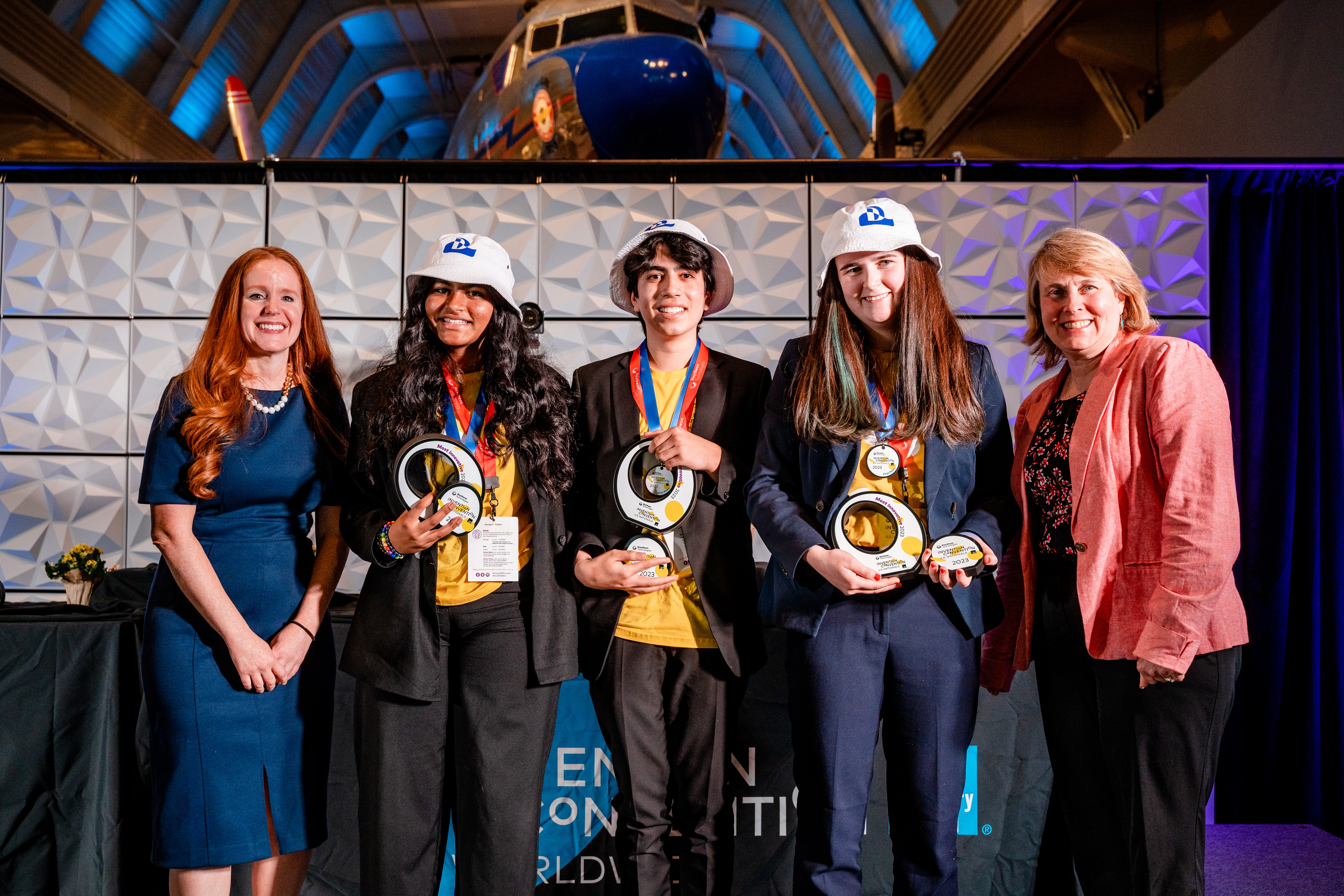 Most Innovative - Dawsonite Diver Team 1 Three students in bucket hats accept circular awards on a stage